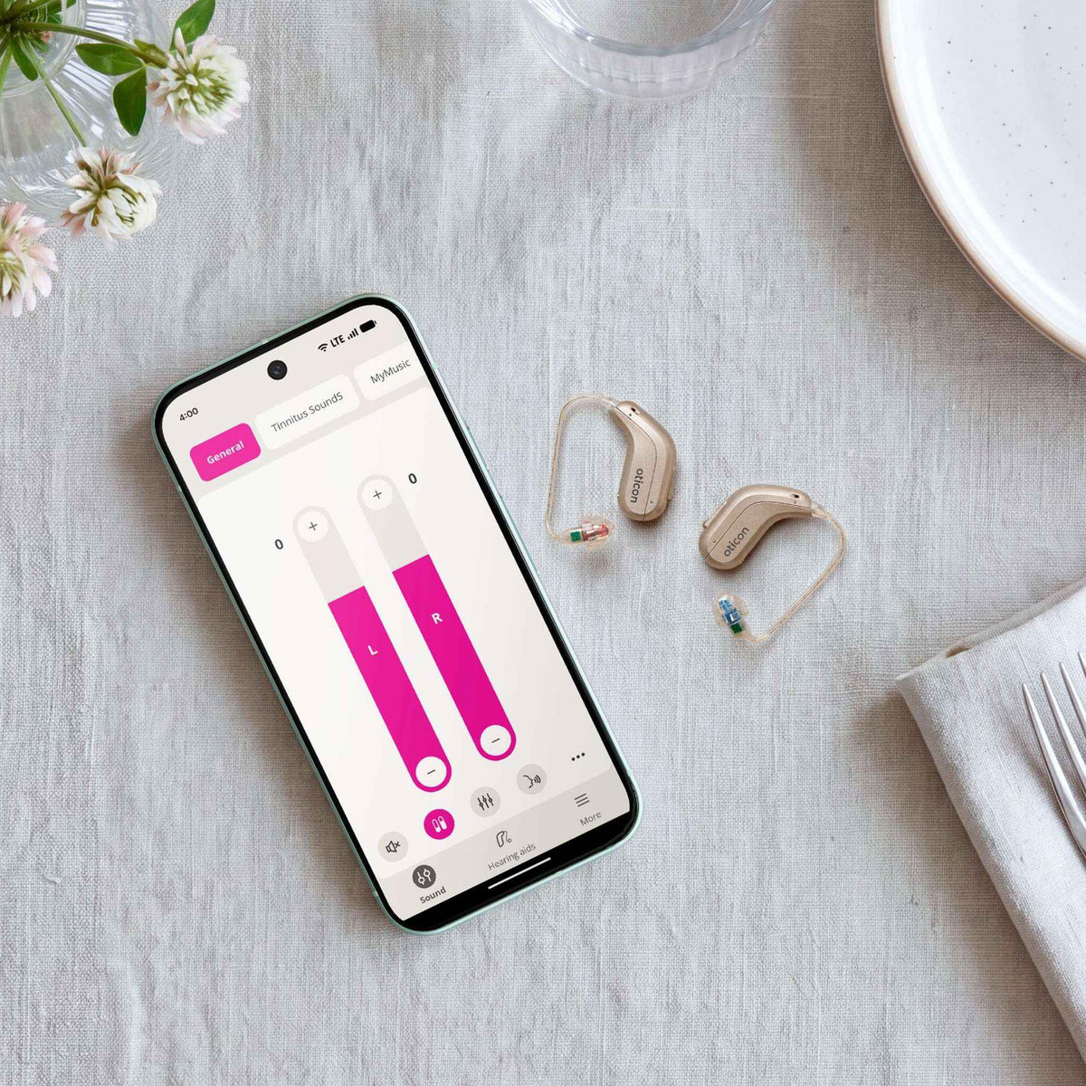 Oticon Reveal Hinter-dem-Ohr-Hörgerät neben einem Smartphone