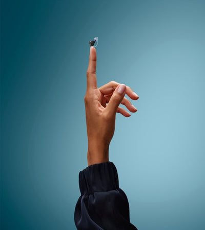 Oticon Zeal Im-Ohr-Hörgerät auf einem Finger balancierend