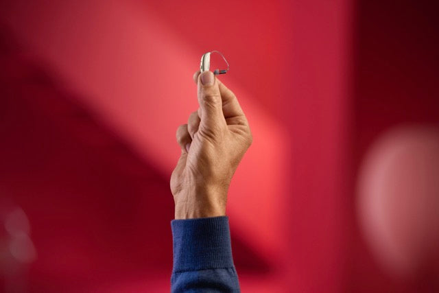 Eine Hand hält ein ReSound Savi Hinter-dem-Ohr-Hörgerät