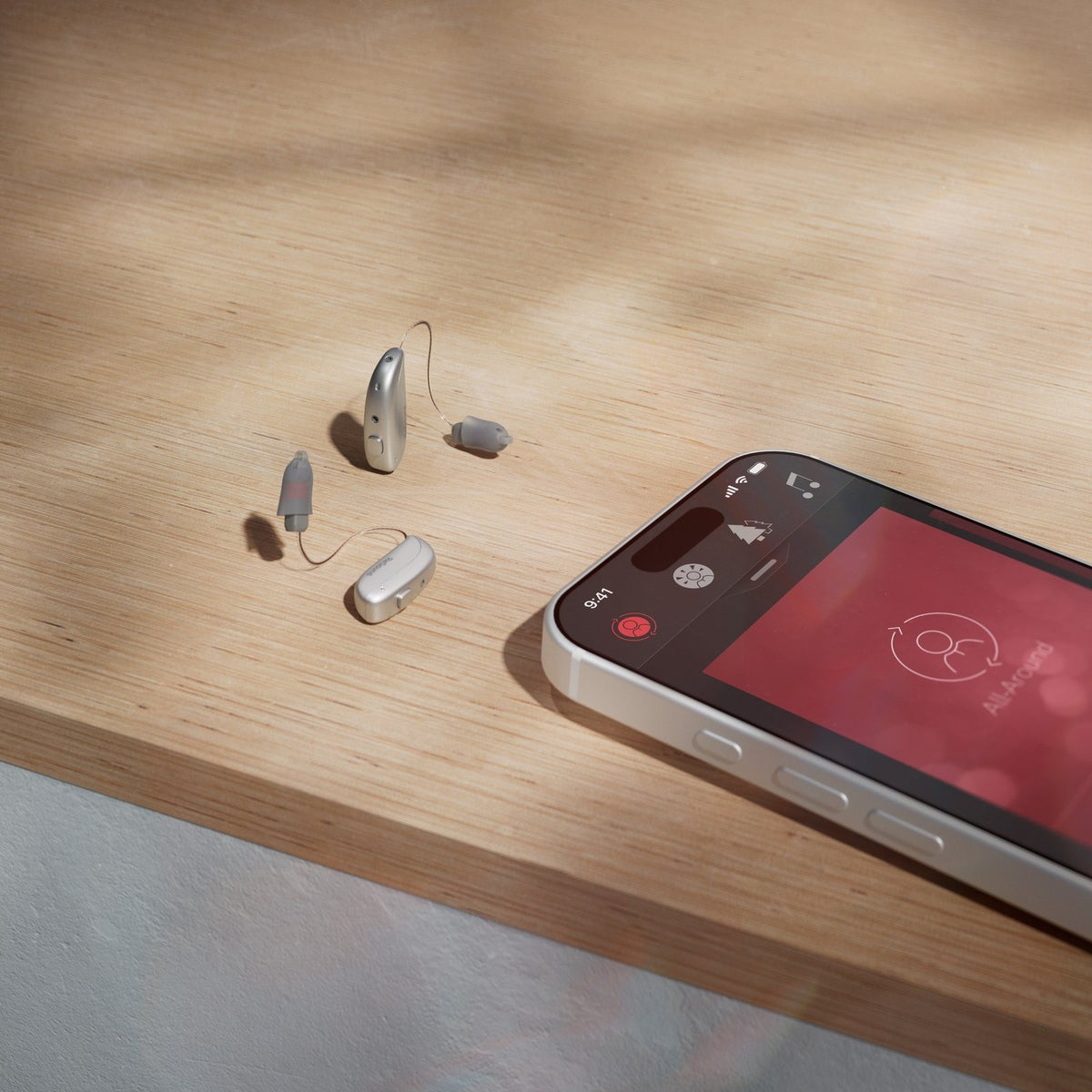 ReSound Sensia Hinter-dem-Ohr-Hörgeräte neben einem Smartphone