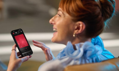 Eine Frau nutzt ReSound Vivia Hinter-dem-Ohr-Hörgeräte mit ihrem iPhone