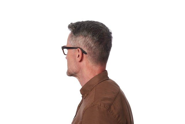 Ein Mann mit Brille trägt ein Starkey Omega AI Hinter-dem-Ohr-Hörgerät